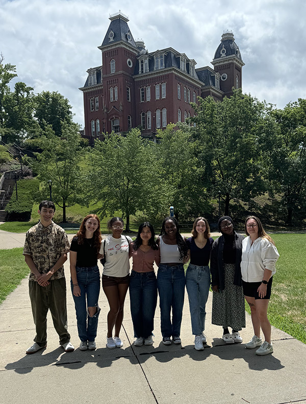 group of students standing in front of an old building